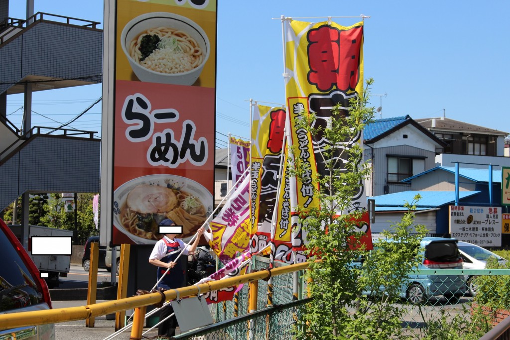 のぼりを交換中の店員さんです。