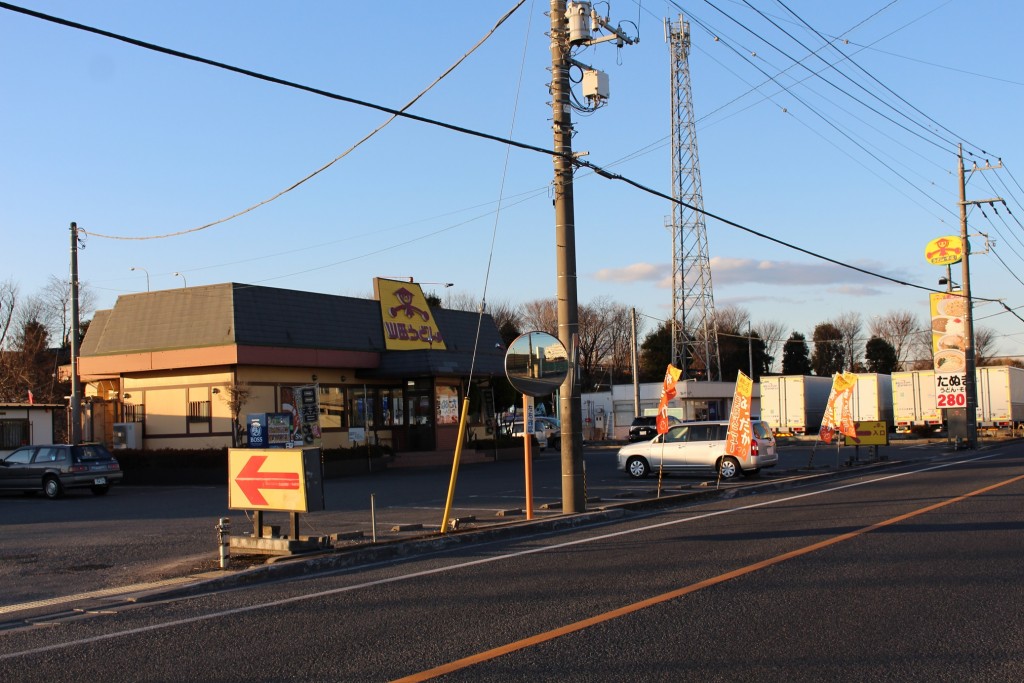 夕日に照らされる日高インター店。